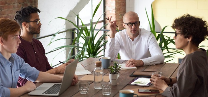 Man in white shirt discussing with colleagues