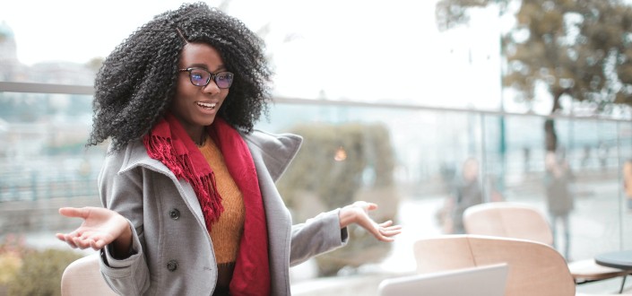 Cheerful surprised woman sitting with laptop