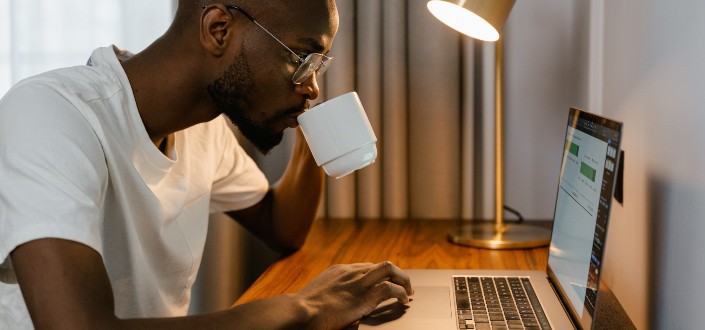 Man drinking coffee while working