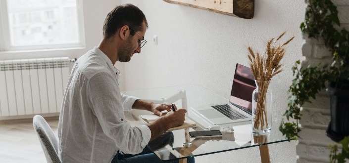 Man in White Shirt Sitting on Chair Writing
