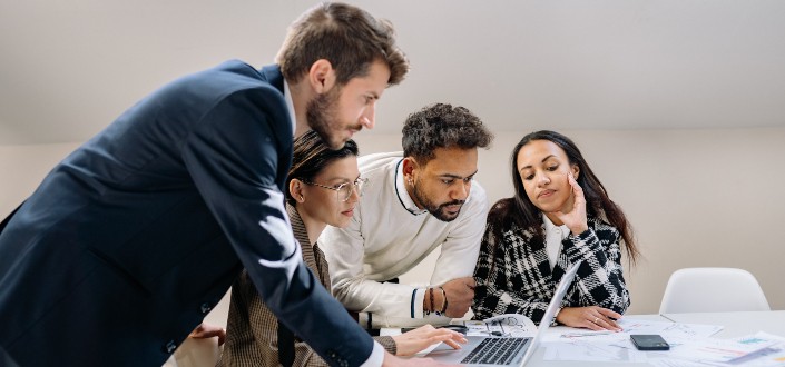Group of People Looking at a Laptop