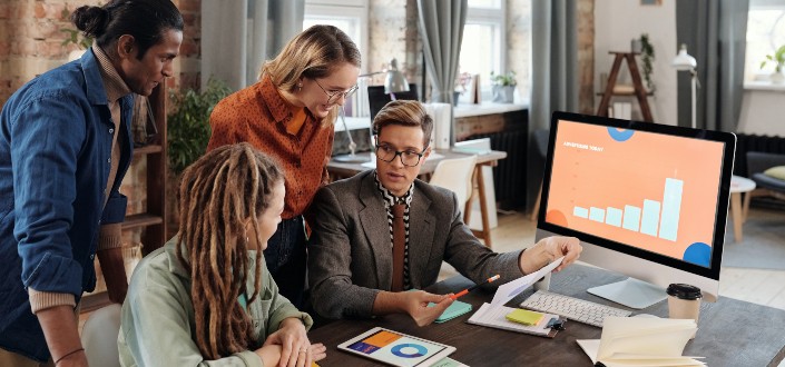  People Discussing Beside a Desktop