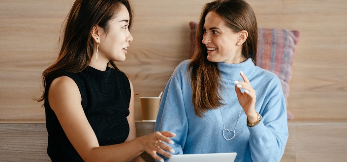 businesswomen with laptop talking about work