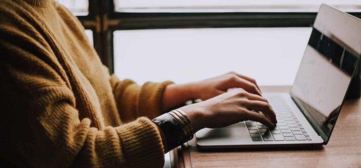 A Man Typing on a Laptop