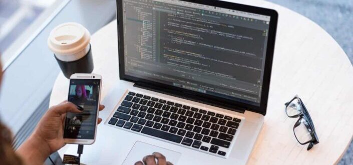 person connecting phone to laptop