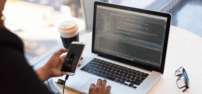 Person Holding Smartphone while using Laptop
