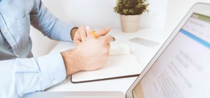Person Holding Pen and Notebook