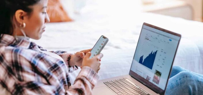 woman using phone and laptop