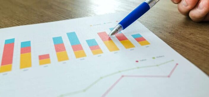 Person Holding Pen Pointing at Graph