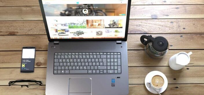 Silver Laptop next to coffee