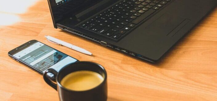 Black Laptop Computer and Black Ceramic Tea Cup